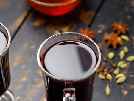 Two glasses of mulled wine and ingredient on dark wooden boards. Spicy warm beverage conceptの写真素材