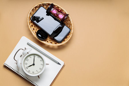 Turned off Electronic Gadgets, Alarm Clock and Notepad on Beige Background, Time Management and...