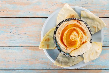 Hummus Bowl with Olive Oil and Pita on Rustic Wooden Background, Copy Space, Top Viewの写真素材