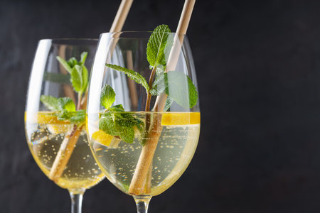 Hugo Spritz Cocktails in Glasses with Mint, Lemon and Cocktail Straws on Dark Background, Copy Spaceの写真素材