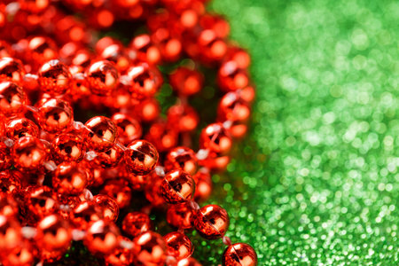 Red Beads on Sparkling Green Background for Cheerful Christmas Decoration Concept, Copy Spaceの写真素材
