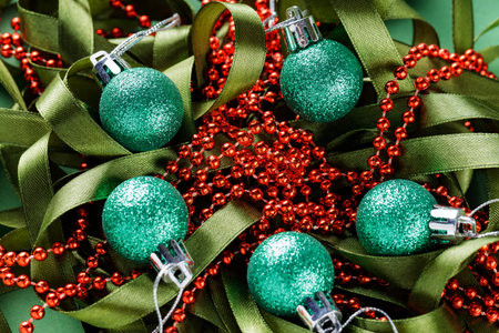 Green Glittery Christmas Ornaments and Red Beads Intertwined with Green Ribbon, Festive and Colorful Holiday Decorationの写真素材