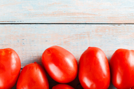 Vibrant Red Tomatoes from Local Harvest on Wooden Table for Sustainable Vegetarian Cooking, Copy Spaceの写真素材