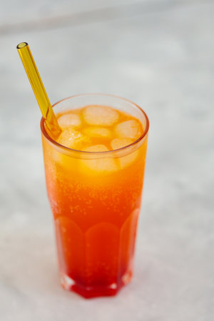 Soda with Ice Cubes in Tall Glass on Gray Background, Trendy Carbonated Drink Conceptの写真素材