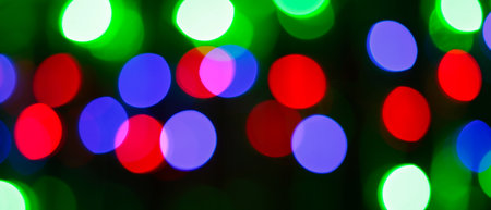 Multicolored Bokeh Background with Blurred Yellow Green Blue Orange Circles on Dark Backgroundの写真素材