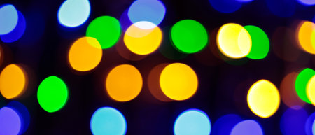 Multicolored Bokeh Background with Blurred Yellow Green Blue Orange Circles on Dark Backgroundの写真素材