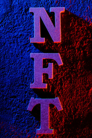 NFT Letters on Textured Wall with Neon Blue and Red Lightingの写真素材