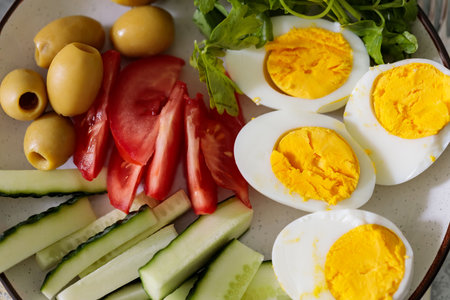 Fresh Healthy Meal with Eggs Cucumber Tomato Olives and Herbsの写真素材