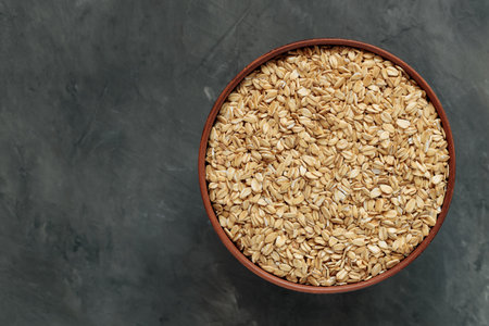 Uncooked Oat Flakes in Rustic Ceramic Bowl Flat Lay Copy Space