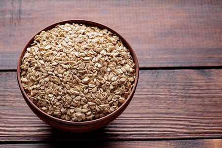 Raw Rolled Oats in Bowl on Dark Wooden Table Copy Space