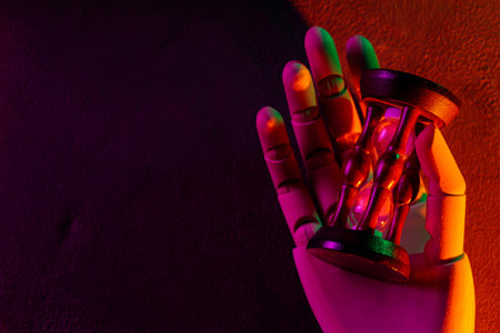 Futuristic Robotic Hand Holding Hourglass in Vibrant Purple Orange Green Neon Lighting