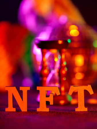 NFT Text Letters with Colorful Bokeh Lights Hourglass in Background Cryptocurrency Concept
