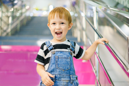 The boy poses, the emotion on his face. Indulge. The boy comes down the stairs in a shopping mallの写真素材