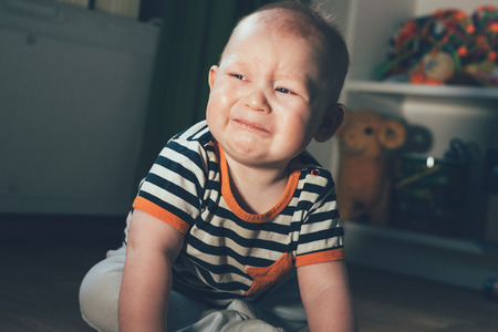 The little boy was crying. The child sits in the room on the floor and roars. Sad and frustratedの写真素材
