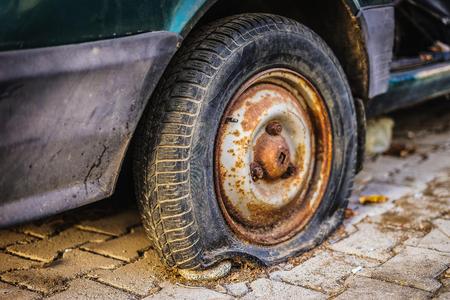 Abandoned rusty car. Flat tire. Old car drive.