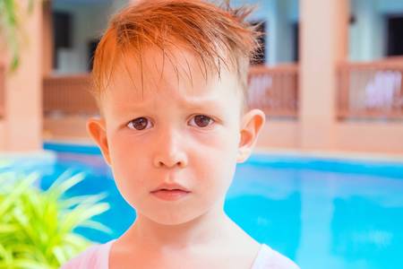 The boy grimaces at the pool on site