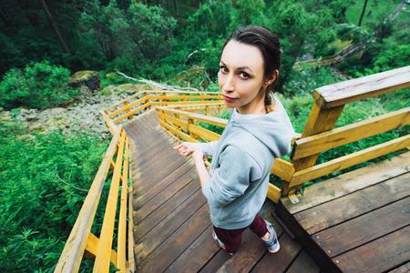 The girl goes down the stairs in the mountains.