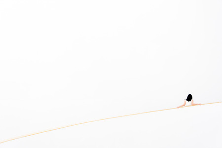 Back side of a woman stand on the stairs with white wall backgroundの写真素材