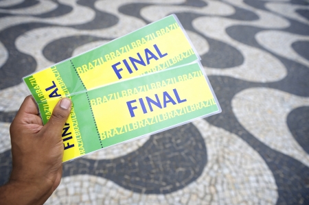 Hand holds pair of tickets to final football soccer World Cup event in Copacabana Rio de Janeiro...