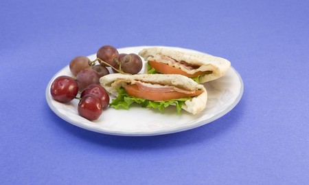 pair of pita pocket blt sandwiches with fruitの写真素材