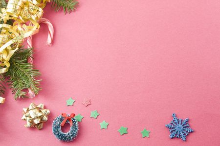 fir branch, gold foil bow, candycane, wreath and stars on textured red backgroundの写真素材