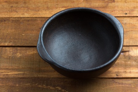 traditional clay pottery plate on the wooden table. toningの写真素材