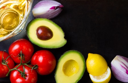 Ingredients for latin american sauce guacamole on black stone backgroundの写真素材