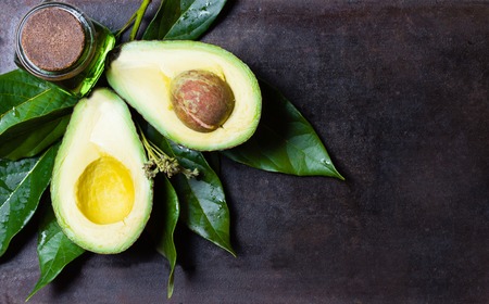 Avocado with leaves black background. top viewの写真素材
