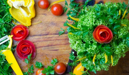 Preparation vegetable bouquet of tomatoes, lettuce, bell paper. Wooden cutting boardの写真素材