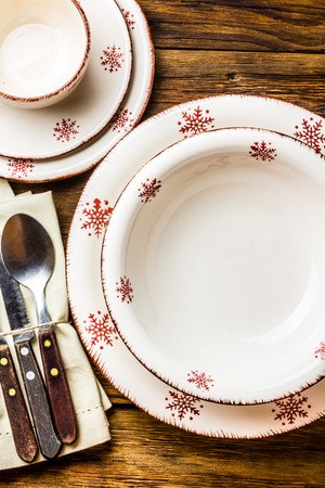 Christmas table setting. Plates, spoon fork knife, Christmas decoration on wooden background. Christmas background. Top viewの写真素材