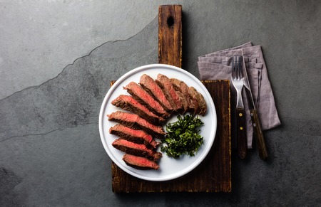 Medium beef steak on white plate, slate background. Top viewの写真素材
