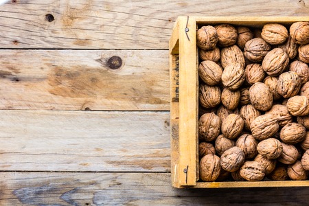 Box of walnuts on wooden background. Harvest conceptの写真素材