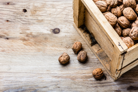 Box of walnuts on wooden background. Harvest conceptの写真素材