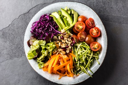 Buddha bowl. Vegetables nuts salad on slate backgroundの写真素材