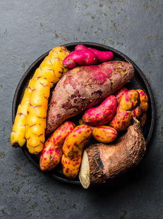 Peruvian raw ingredients for cooking - yuca, colored sweet potatoes and camote batata. Top view.の写真素材
