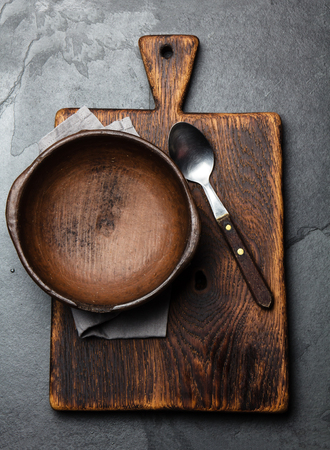 Cooking background. Vintage empty clay bowl on cutting boards, copy space.の写真素材