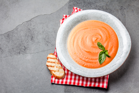 Traditional spanish andalusian tomato cream soup - salmorejo. Salmorejo or gazpacho cream soup on gray bowl, slate gray backgroundの写真素材