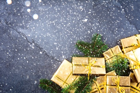 Christmas background. Golden gift boxes on slate background. Flat lay, top view