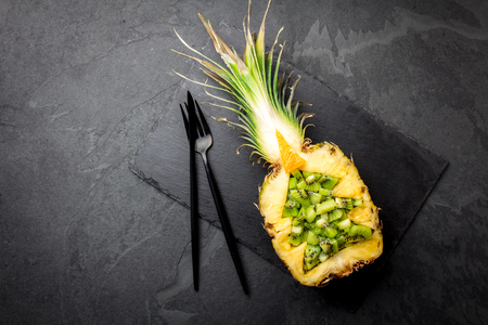 Holiday diet concept or tropical Christmas menu concept. Christmas tree made from pineapple and kiwi on slate board. Ideas for Christmas New Year menuの写真素材