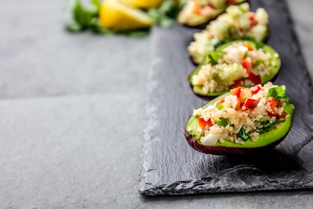 Tradition peruvian quinua quinoa salad served in avocado half, slate boardの写真素材