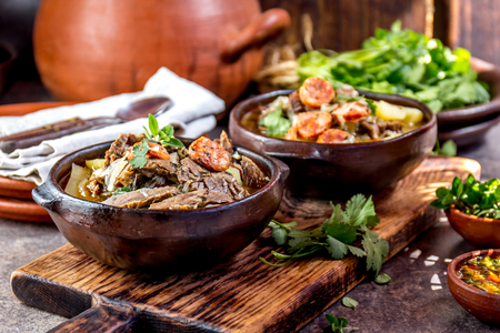 Chilean Ajiaco. Latin American food. Ajiaco - traditional chilean soup with grilled meat, onion and potato served in clay platesの写真素材