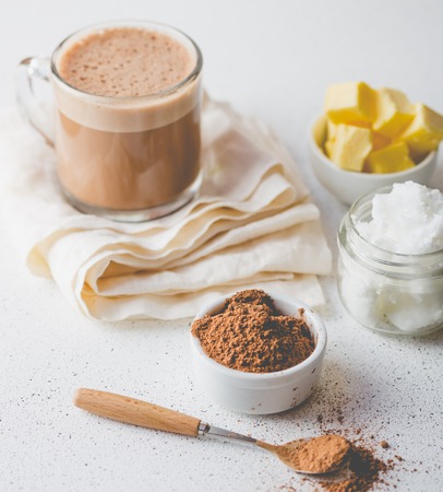 Ketogenic keto diet hot drink. Cacao blended with coconut oil and butter. Cup of  cacao and ingredients on white backgroundの写真素材