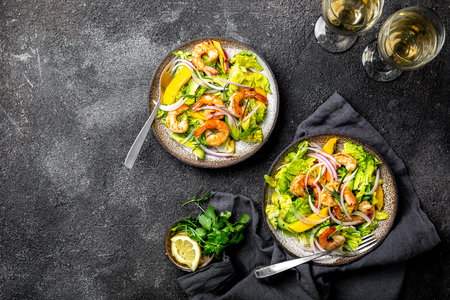 Fresh Shrimps, Mango Avocado lettuce salad, olive oil and lemon dressing. healthy food. Top view, gray backgroundの写真素材