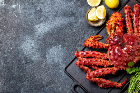 Red king crab on gray background. King crab, lemon and cilantro, top viewの写真素材