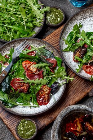 Salad with arugula, spinach, dried tomato and ham serrano paleta iberica. Low carbs keto recipe.の写真素材