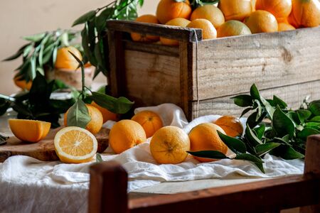Table with box of fresh orange with orange tree branch and fresh orange juiceの写真素材