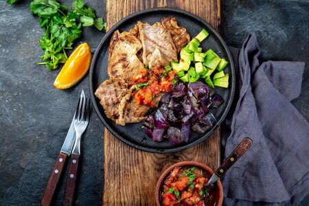Yucatan Mexican Food Pork POC CHUC poc chuck. Pork marinaded in orange juice served with avocado, purple onion and rustic tomato sauce.の写真素材