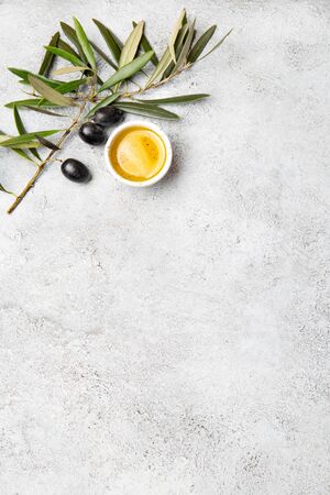 Food background with linen napkin, olive tree branch, olive oil on concrete background.の写真素材
