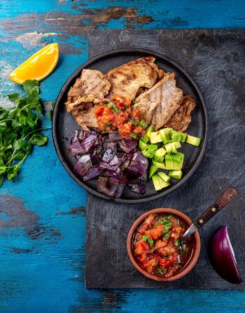 Yucatan Mexican Food Pork POC CHUC poc chuck. Pork marinaded in orange juice served with avocado, purple onion and rustic tomato sauceの写真素材