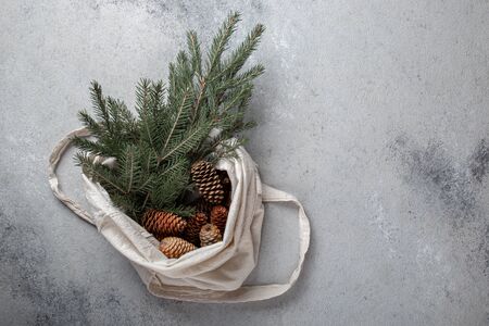Zero waste Christmas concept. Natural Chirsmas decoration, pine cones and branches in linen bag. Flat lay, top viewの写真素材